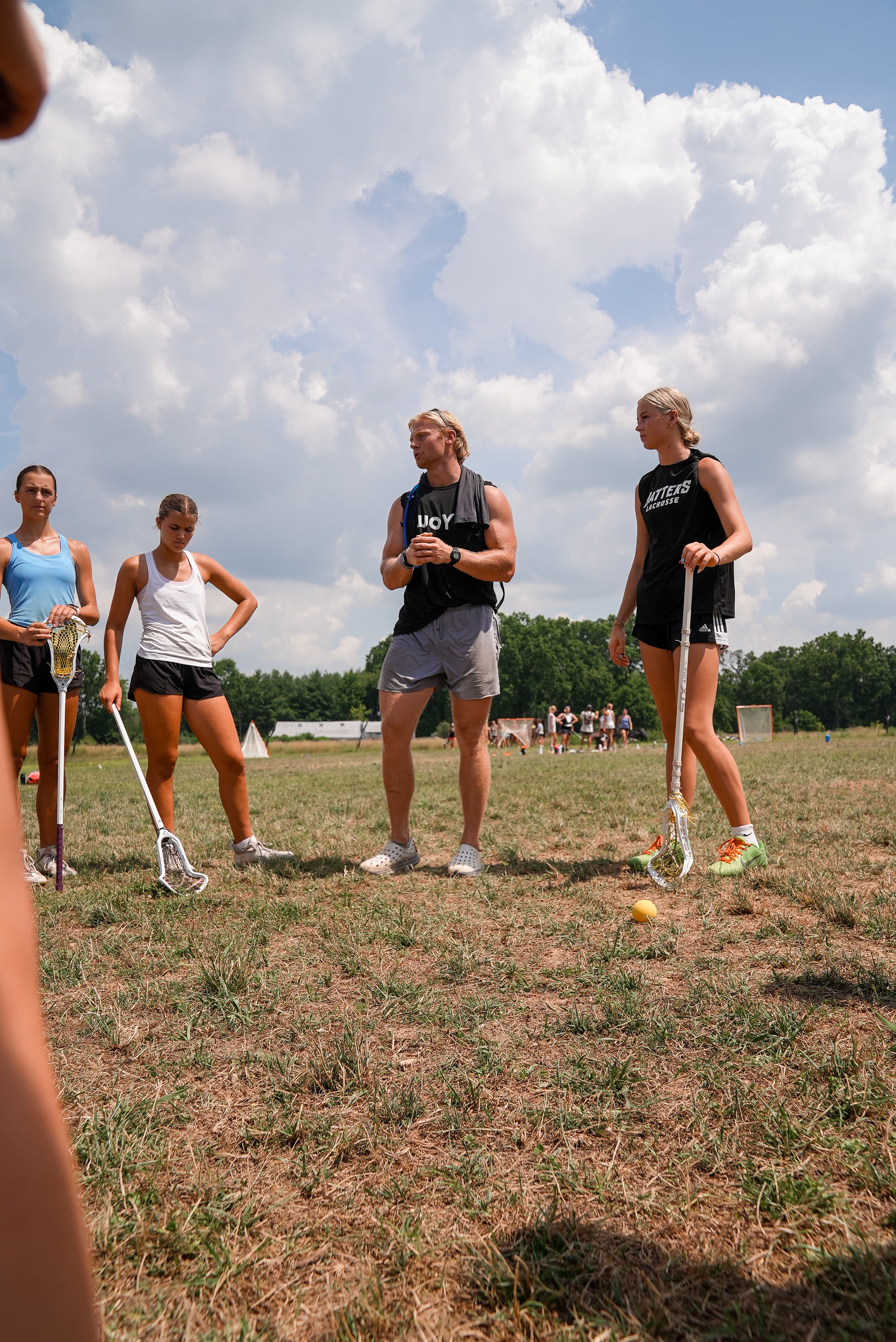 Harrison Schertzinger coaching lacrosse athletes on the field