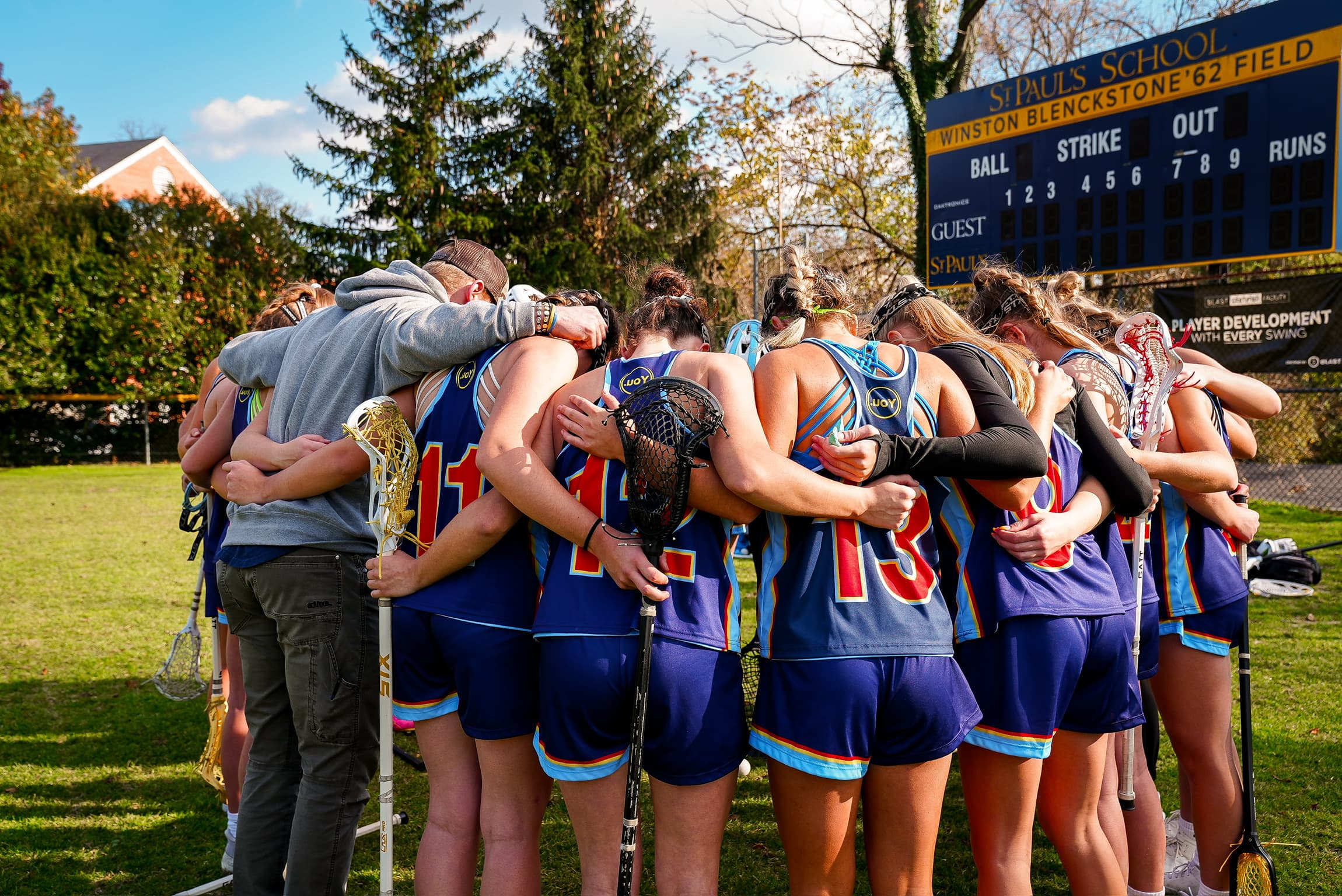 Harrison Schertzinger huddling with his lacrosse team on the field